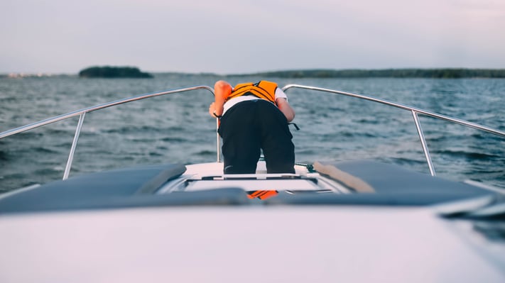 person-being-seasick-at-the-bow-of-a-boat